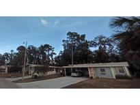 Cozy one-story home featuring a covered carport and a well-maintained front yard at 2808 Manatee Rd, Tavares, FL 32778