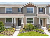 Charming townhome featuring a landscaped front yard, neutral siding, and a welcoming entrance with stone-accented columns at 3029 Douglas Fir Dr, Apopka, FL 32703