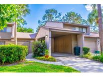 Charming townhome showcasing a covered carport, complemented by mature landscaping and verdant green spaces at 458 Meadowood Blvd, Fern Park, FL 32730