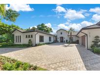 Stunning exterior view of home showcasing paver driveway and lush landscaping at 5157 Latrobe Dr, Windermere, FL 34786