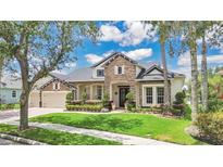 Charming home featuring stone accents, lush landscaping, and a well-manicured lawn at 5944 Lake Melrose Dr, Orlando, FL 32829