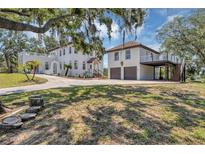 Sprawling estate with a white stucco exterior, red tile roof, and lush greenery, showcasing curb appeal at 802 S 10Th St, Haines City, FL 33844