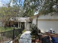 Home exterior showcasing a walkway and garage, framed by lush greenery at 9325 Echo Run, Orlando, FL 32817