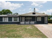 Charming single-story home featuring a blue exterior, brick accents, and a well-maintained lawn and driveway at 5723 Harcourt Ave, Orlando, FL 32810