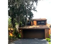 Home exterior with a drive-in garage in a lush environment at 104 Oaks Ct, Sanford, FL 32771