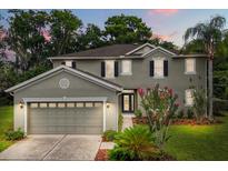 Inviting two-story home featuring a well-manicured lawn, attached garage, and decorative shutters at 1203 Stone Harbour Rd, Winter Springs, FL 32708