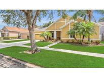 Charming single Gathering home with a lush lawn, mature trees, and well-manicured landscaping at 14312 Paradise Tree Dr, Orlando, FL 32828
