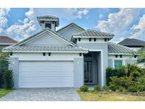 Charming one-story home featuring a tiled roof, well-manicured landscaping, and a two-car garage at 148 Hampton Loop, Davenport, FL 33837