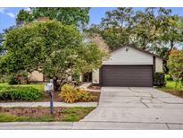 Charming single-story home with a well-maintained lawn, mature trees, and a two-car garage at 1508 Southwind Ct, Casselberry, FL 32707