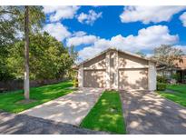 Two-car garage with well-manicured lawn and lush landscaping at 168 Hill St, Casselberry, FL 32707