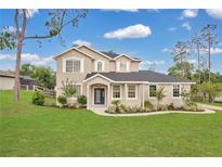 Beautifully landscaped two-story home with a blue front door and lush green lawn at 17657 Windy Pine St, Montverde, FL 34756