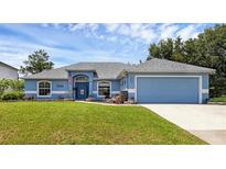 Charming one-story home featuring a well-manicured lawn and a bright blue exterior at 2963 Beckwith St, Deltona, FL 32738