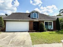 Charming single-story home with a two-car garage, brick facade, and well-manicured lawn at 4186 Buglers Rest Pl, Casselberry, FL 32707