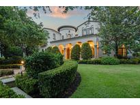 Stately home with a lush green lawn, arched entry and manicured landscaping at 4400 New Broad St, Orlando, FL 32814