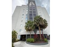 Modern building with palm trees and manicured landscaping offering a luxurious and inviting curb appeal at 6165 Carrier Dr # 1801, Orlando, FL 32819