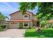 Charming two-story home featuring well-manicured landscaping, a brick driveway, and a welcoming front entrance at 6460 Parson Brown Dr, Orlando, FL 32819