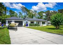 Charming single-story home with a boat in the driveway and a well-maintained lawn at 655 N Arnold Ave, Groveland, FL 34736