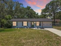 Charming single-story home with a well-maintained lawn, freshly painted exterior, and lovely curb appeal at sunset at 7375 Lake Dr, Sanford, FL 32771