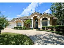 Inviting single-story home with a well-manicured lawn, mature landscaping, and a spacious driveway at 787 High Grove Park Ct, Oviedo, FL 32765