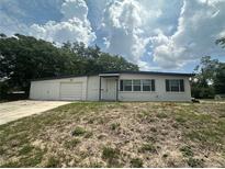 Charming single-story home featuring a large front yard and attached garage at 795 Temple Ave, Orange City, FL 32763