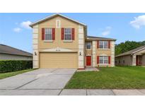 Two-story home with a neutral color scheme, red shutters, and a well-maintained front lawn at 806 Sterling Spring Rd, Orlando, FL 32828