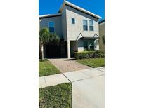Modern two-story home featuring a stone-accented garage and manicured landscaping at 851 Drop Shot Dr, Davenport, FL 33896