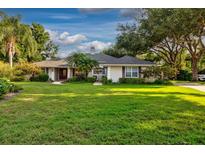 Charming single-story home featuring a well-manicured lawn, mature trees, and inviting curb appeal at 1947 Broadleaf Ct, Windermere, FL 34786