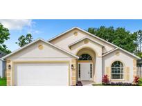 Charming single-Gathering home featuring a two-car garage, arched entryway, and well-maintained landscaping at 2124 Fish Eagle St, Clermont, FL 34714