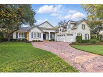Beautiful home exterior boasts brick driveway, manicured lawn, and charming architectural details at 267 Osprey Hammock Trl, Sanford, FL 32771