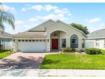 Charming single-story home with a red front door, manicured lawn, and brick paved driveway at 2729 Stanwood Dr, Kissimmee, FL 34743