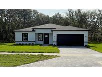 Charming single story home with black trim, a well-manicured lawn, and a paved driveway at 285 Marion Oaks Crse, Ocala, FL 34473