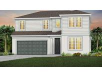 Charming two-story home featuring a two-car garage, well-maintained lawn, and classic white siding at 3373 Orange Rose Loop, Apopka, FL 32712
