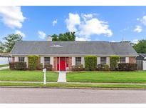 Charming single-story brick home with well-manicured lawn and bright red front door at 407 Westchester Dr, Altamonte Springs, FL 32701