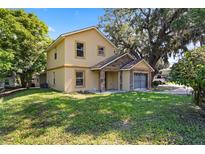 Charming two-story home with stone accents and a well-maintained lawn and mature landscaping at 500 W Oakland Ave, Oakland, FL 34760