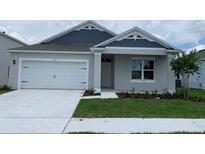Charming single-story home featuring a two-car garage, well-maintained lawn, and inviting front entrance at 5267 Flameleaf St, Apopka, FL 32712