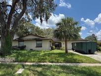 Inviting single-story home featuring a charming front yard with mature trees and lush greenery at 6616 Blanche Ct, Orlando, FL 32818