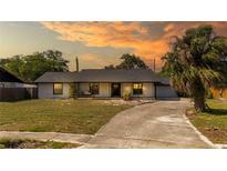 Charming single-story home with a well-manicured lawn and beautiful, mature landscaping at 765 Coachlight Dr, Casselberry, FL 32730