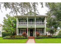 Charming two-story home with inviting front porch, lush landscaping, and a well-manicured lawn at 8335 Lake Burden Circle, Windermere, FL 34786