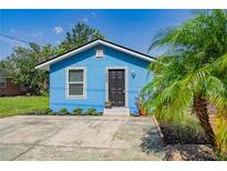 Charming blue one-story home with a well-kept lawn and freshly painted front door at 1002 S Locust Ave, Sanford, FL 32771