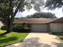 Charming single-story home featuring a well-maintained lawn, mature trees and a two-car garage at 106 Water Oak Dr, Sanford, FL 32773