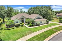 Charming single-story home featuring a lush green lawn and meticulously manicured landscaping at 11602 Graces Way, Clermont, FL 34711