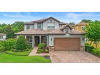Charming two-story home featuring a well-manicured lawn, brick driveway, and a cozy front entrance at 1365 Tappie Toorie Cir, Lake Mary, FL 32746
