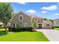 Charming two-story home featuring a well-manicured lawn and beautiful landscaping at 1425 Riviera Dr, Kissimmee, FL 34744