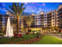 Stunning condo building with lush landscaping, a water fountain, and a grand entrance at 14501 Grove Resort Ave # 2440, Winter Garden, FL 34787