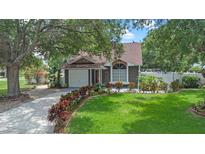 Charming single-Gathering home boasts a well-manicured lawn, flower beds, and a cozy front porch at 202 Ferryboat Ct, Orlando, FL 32828