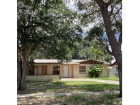 Traditional single-story home featuring a well-manicured front yard with a brick-paved driveway and mature landscaping at 2023 Messina Ave, Orlando, FL 32811