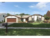 Charming single-story home with a well-manicured lawn, stone accents, and a two-car garage at 414 Bonifay Ave, Orlando, FL 32825