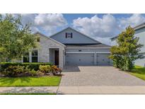 Beautiful two-story home with gray siding, stone accents, and a three-car garage at 4632 Egg Harbor Dr, Kissimmee, FL 34746