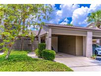 Charming exterior view featuring a covered carport, lush landscaping, and neutral color palette at 489 Meadowood Blvd, Fern Park, FL 32730