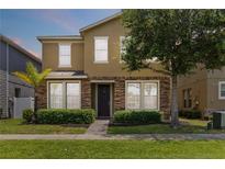 Charming two-story home featuring a stone facade, manicured landscaping, and a welcoming front entrance at 5217 Creekside Park Ave, Orlando, FL 32811